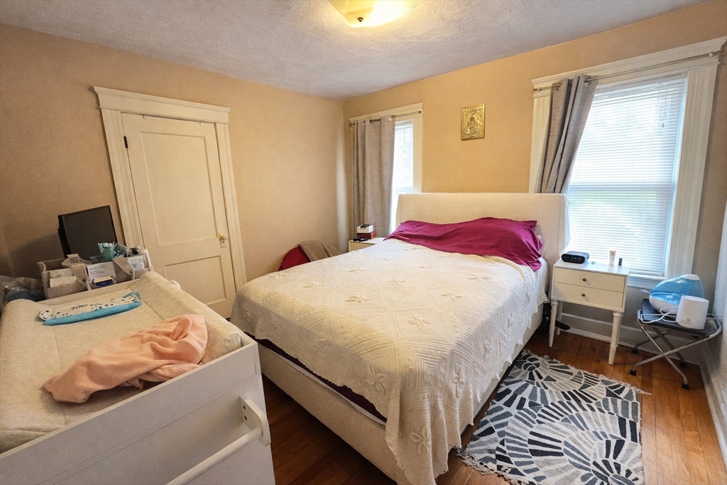 328 Brooks Street Worcester, MA 01606 - Photo 32 of 32 a bedroom with a bed and wooden floor