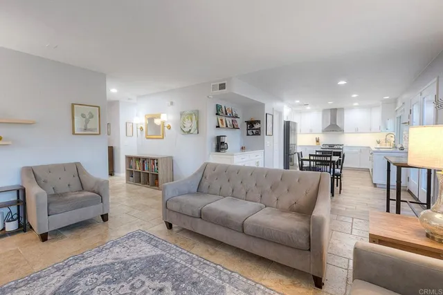 a kitchen with stainless steel appliances granite countertop a refrigerator stove a sink and white cabinets with wooden floors