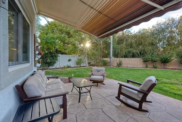 a backyard of a house with table and sofas