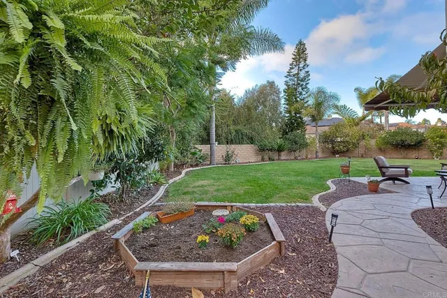 a view of a house with a big yard and large trees