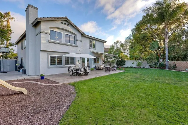 a aerial view of a house with a yard and large trees
