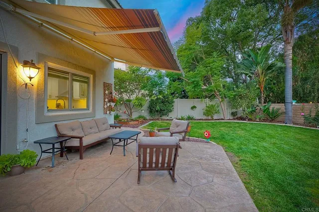 a view of a patio with table and chairs potted plants with wooden floor and fence