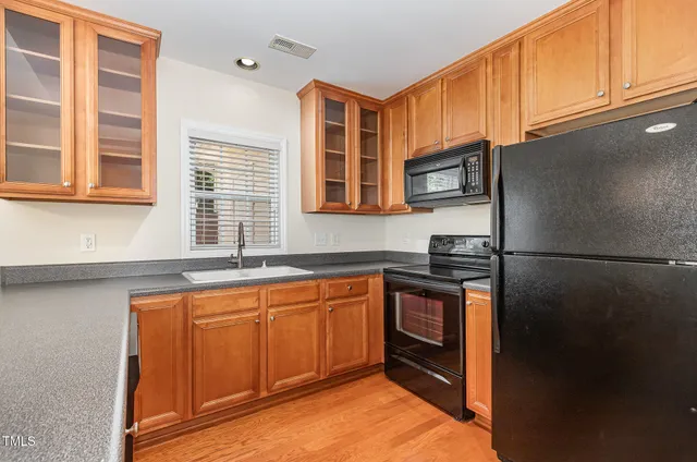 a kitchen with stainless steel appliances granite countertop a refrigerator and a sink