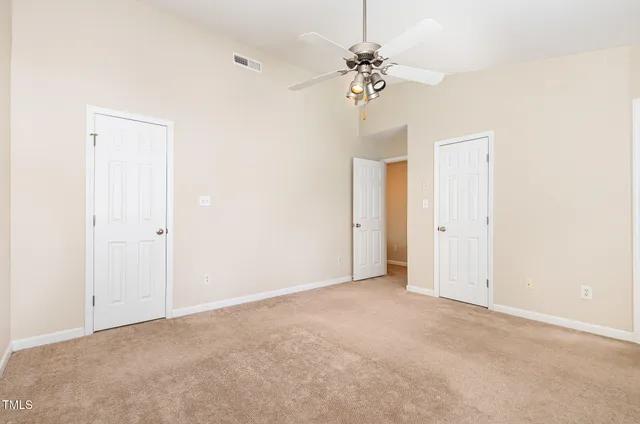 an empty room with a chandelier fan