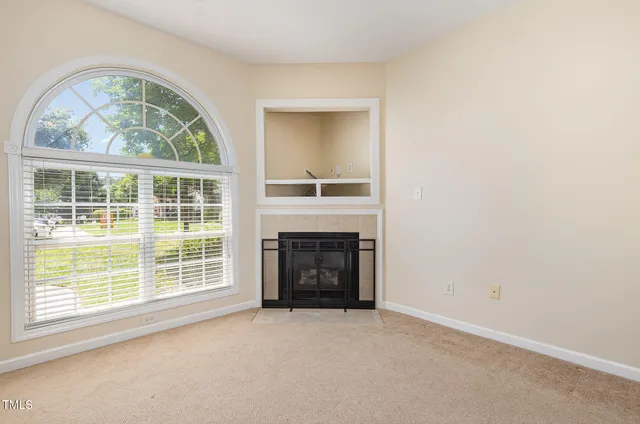 an empty room with windows fire place and a window