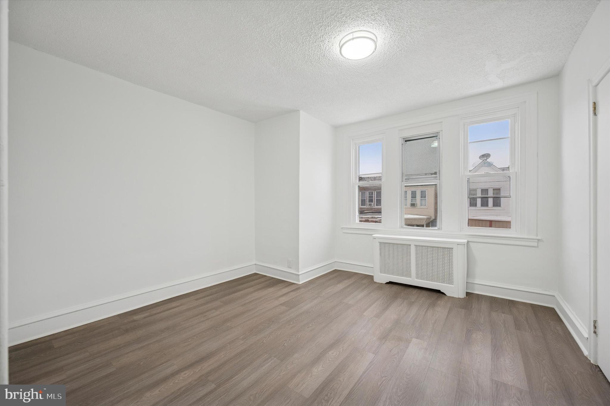 892 Granite Street Philadelphia, PA 19124 - Photo 11 of 15 an empty room with wooden floor and windows