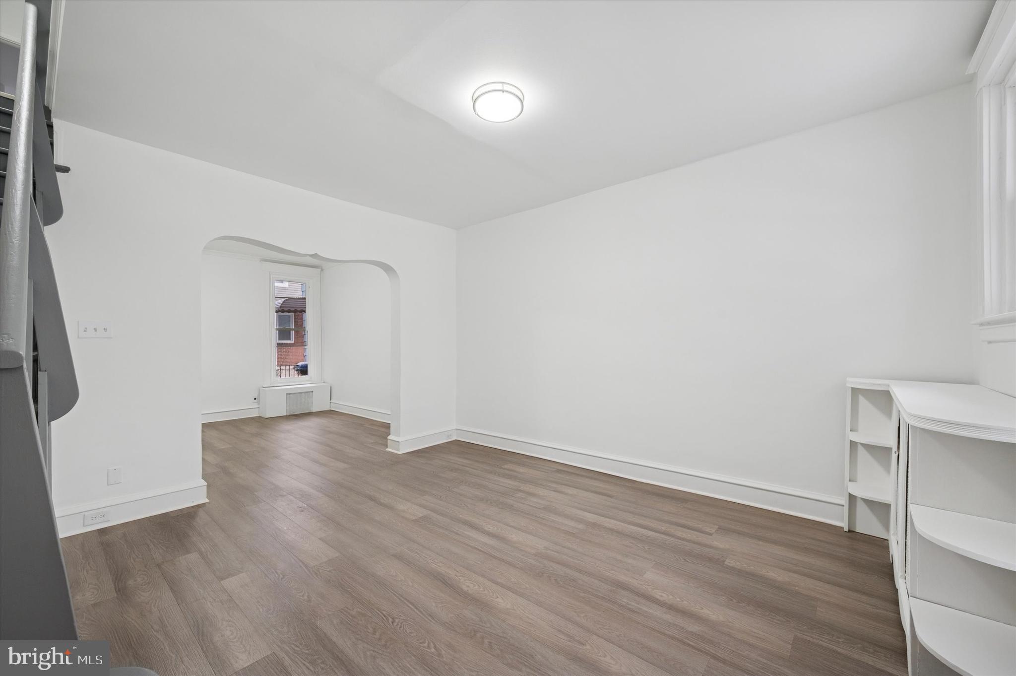 892 Granite Street Philadelphia, PA 19124 - Photo 2 of 15 an empty room with wooden floor and windows