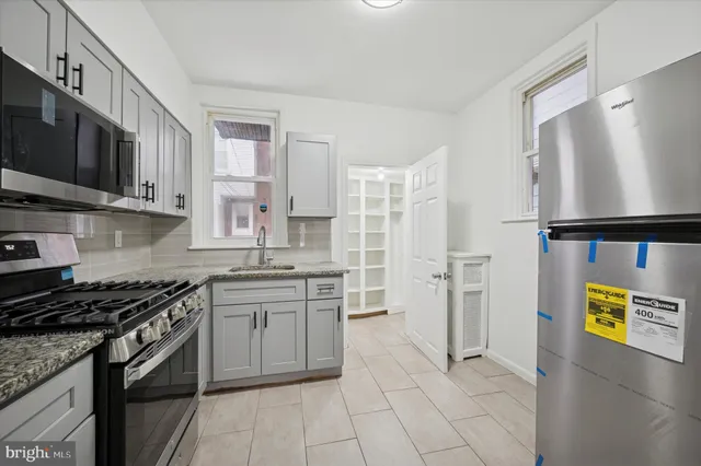 a kitchen with stainless steel appliances granite countertop a stove a sink and a refrigerator