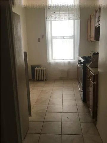 a kitchen with a window a counter top space and cabinets
