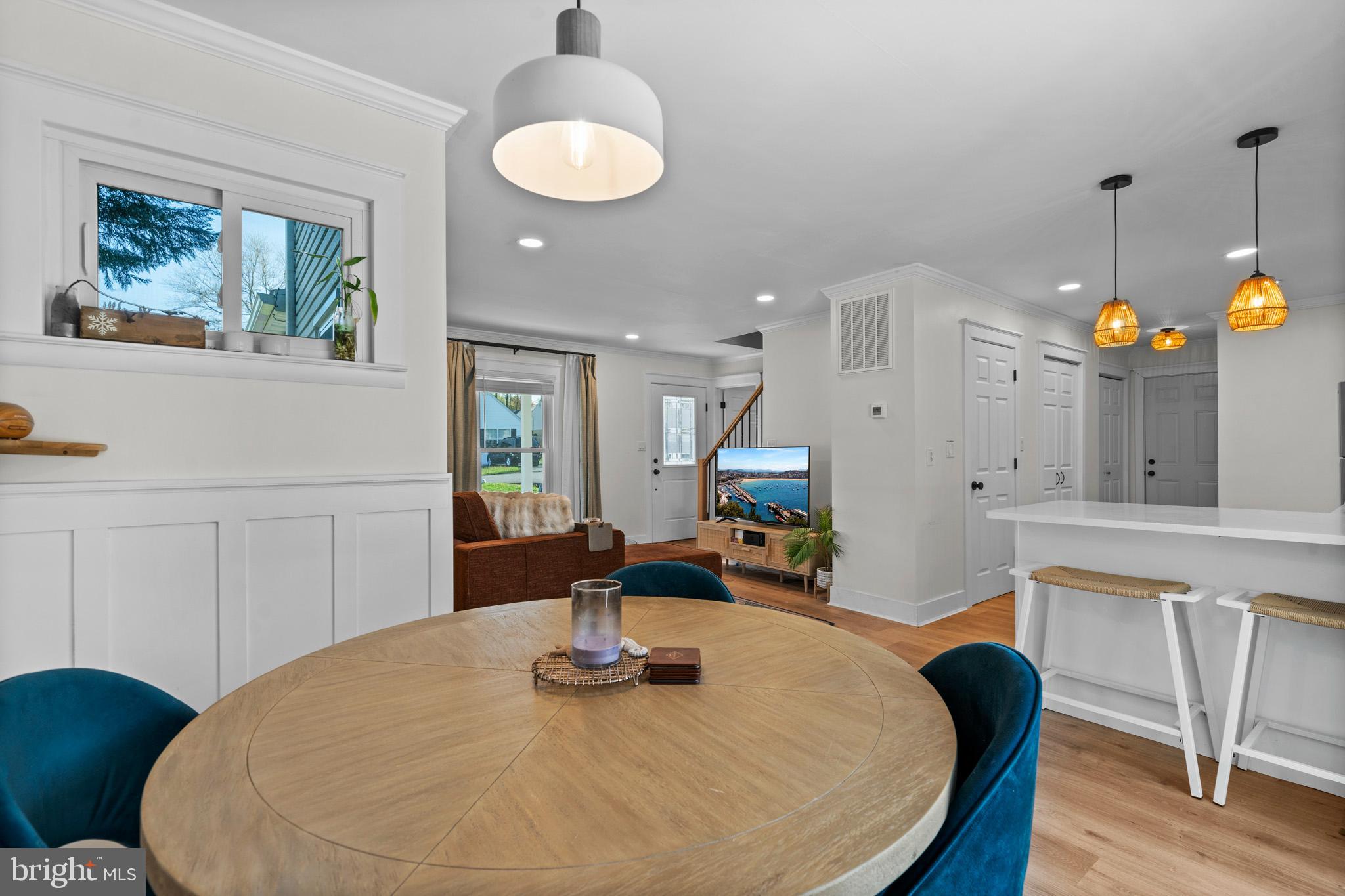 3704 9th Street North Beach, MD 20714 - Photo 11 of 42 a kitchen with stainless steel appliances granite countertop a sink a microwave a dining table and chairs with wooden floor