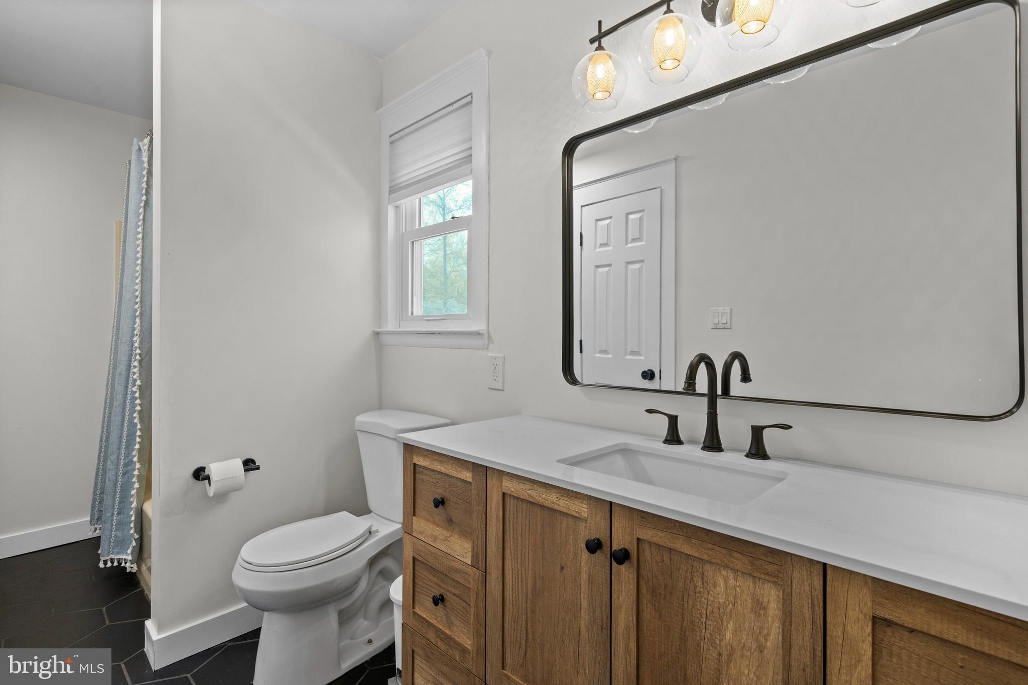 3704 9th Street North Beach, MD 20714 - Photo 21 of 42 a bathroom with a toilet sink and mirror