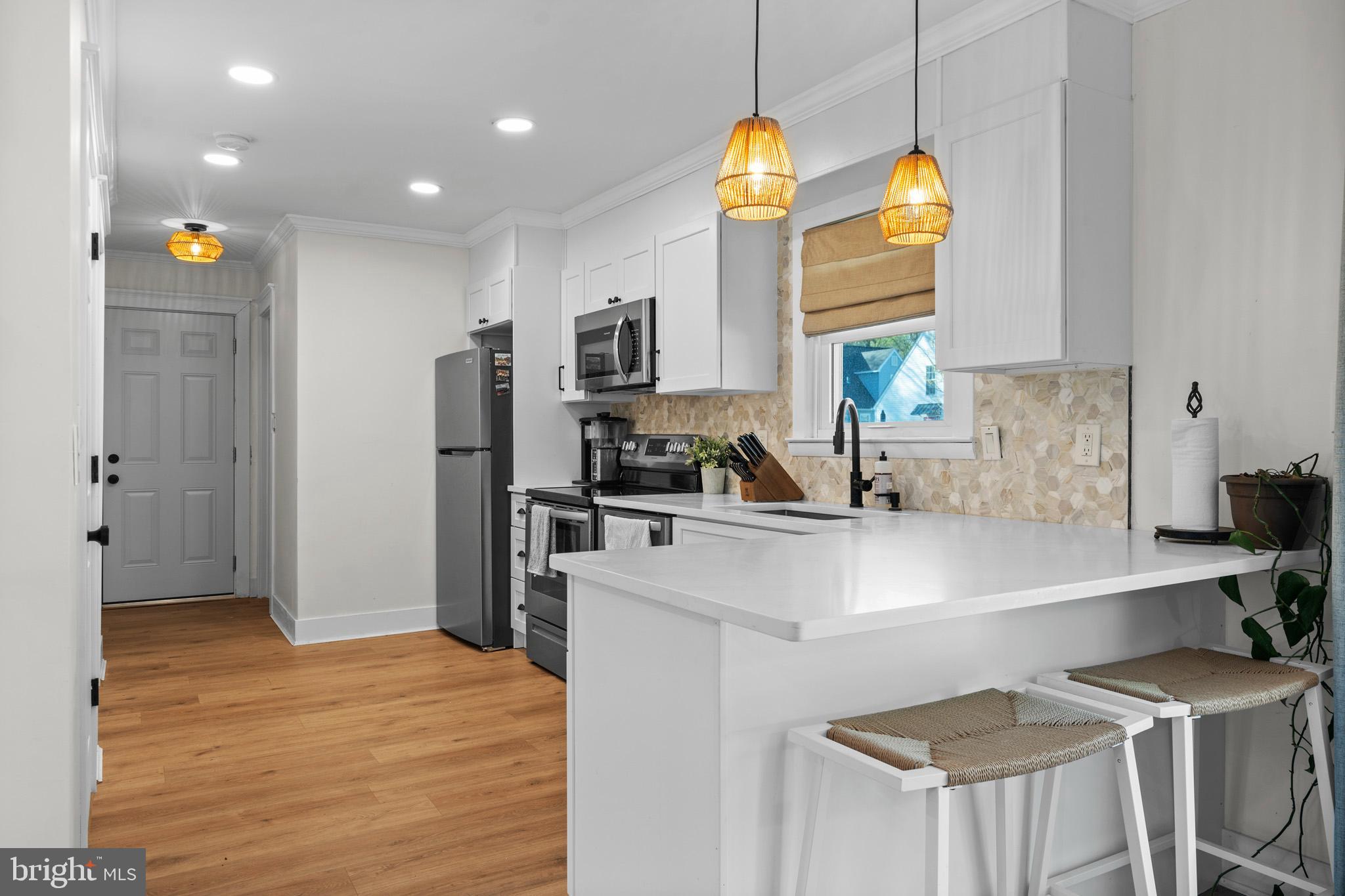 3704 9th Street North Beach, MD 20714 - Photo 5 of 42 a kitchen with stainless steel appliances granite countertop a sink a stove and a refrigerator