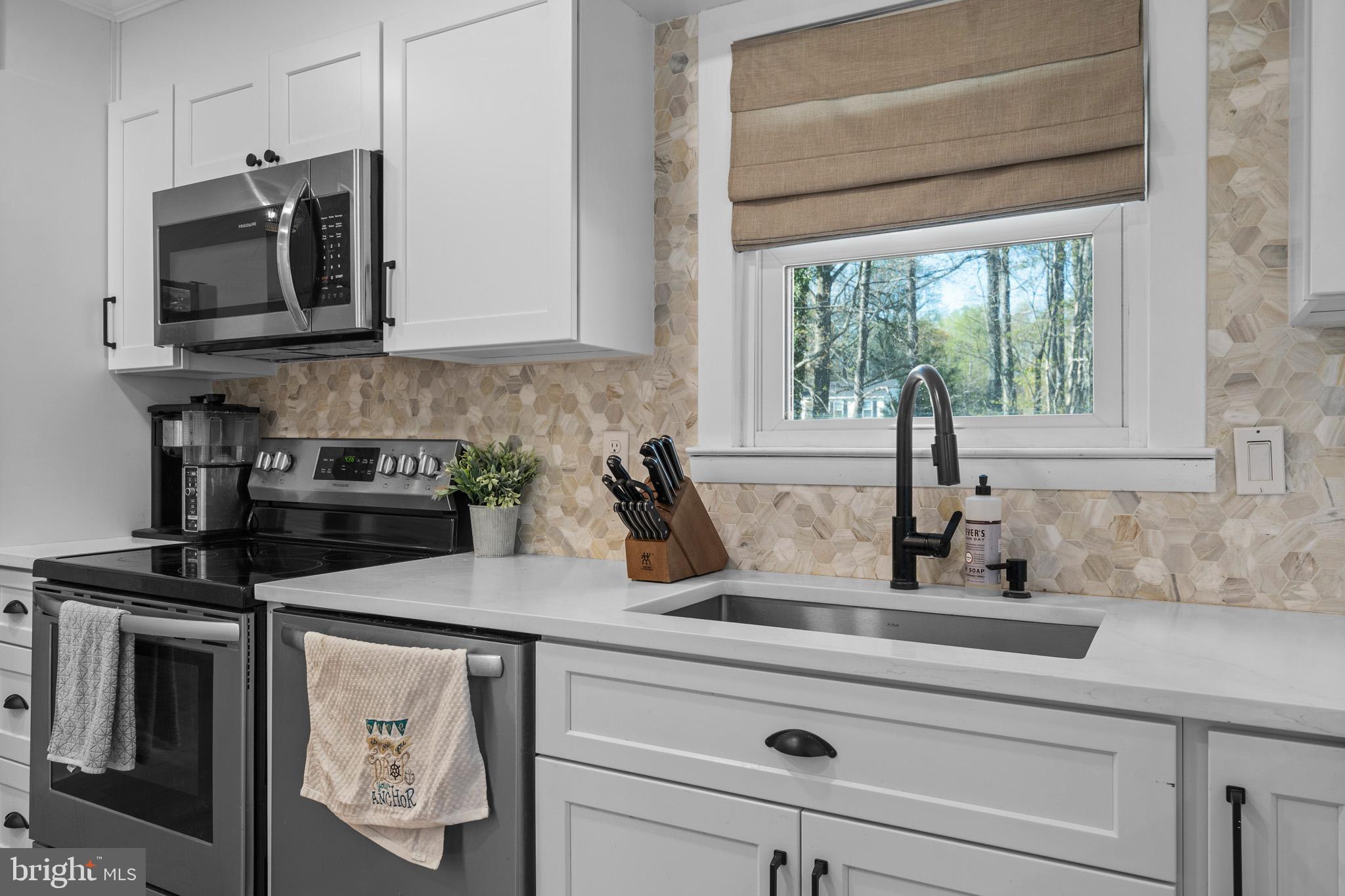 3704 9th Street North Beach, MD 20714 - Photo 7 of 42 a kitchen with a stove a sink and a microwave