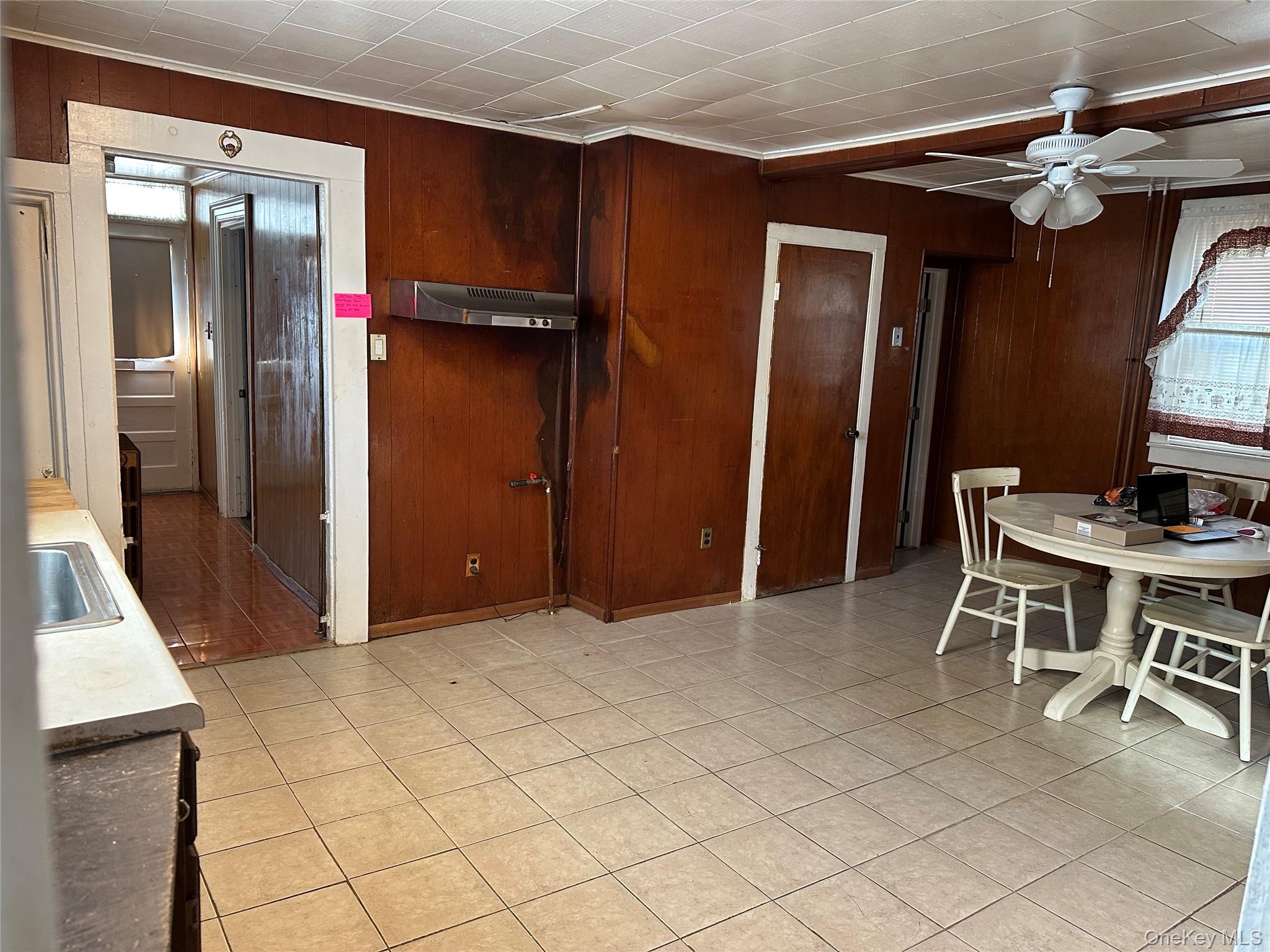 76 Church Street Beacon, NY 12508 - Photo 6 of 26 Dining space with ceiling fan, wood walls, and light tile patterned floors