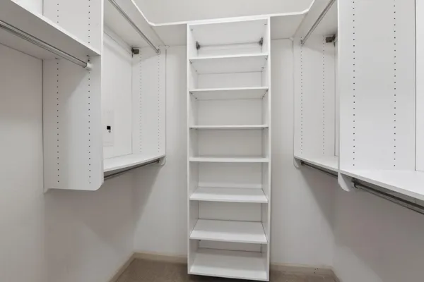 a view of walk in closet with empty racks