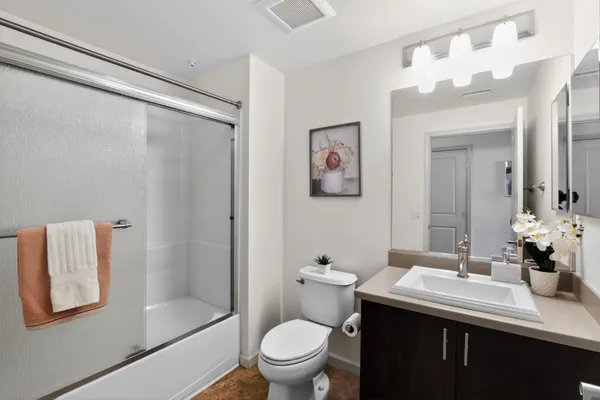 a bathroom with a sink vanity mirror and toilet