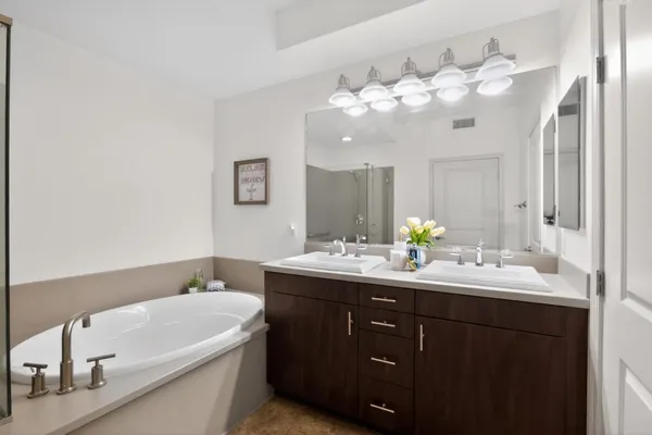 a bathroom with a tub a sink and mirror