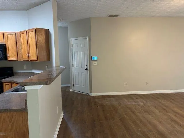 a view of kitchen with granite countertop cabinets and sink