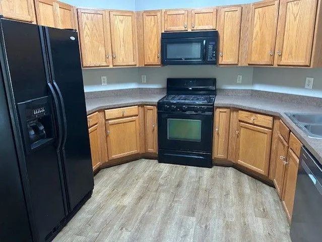 a kitchen with granite countertop a refrigerator stove and sink