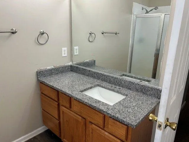 a bathroom with a granite countertop sink and a mirror