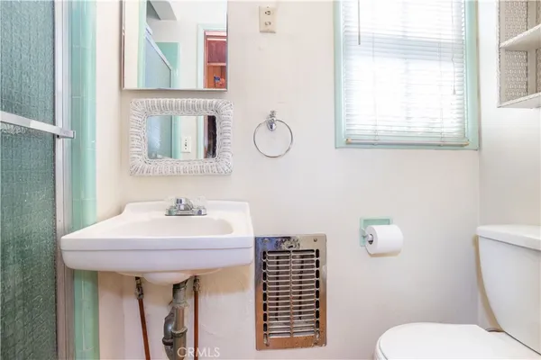 a bathroom with a sink toilet and a mirror
