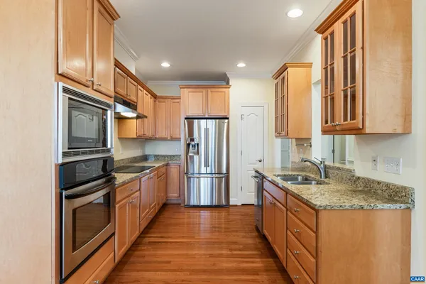 a kitchen with stainless steel appliances granite countertop a stove a sink and a refrigerator