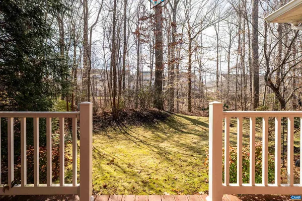 a view of small yard with large trees and wooden fence