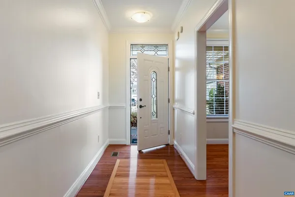 a view of a hallway with wooden floor and staircase