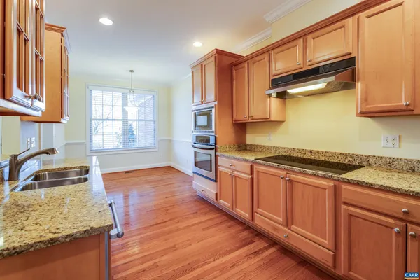 a kitchen with granite countertop wooden floors and wide window