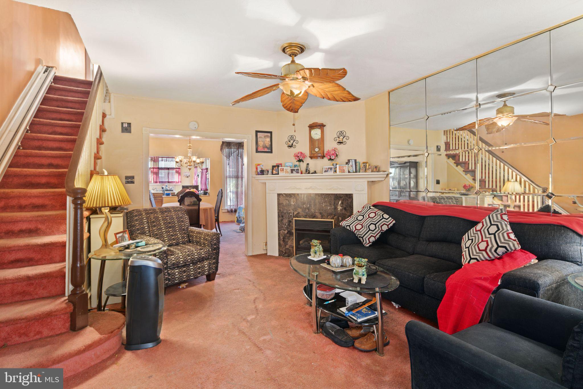 7818 Lennox Road Upper Darby, PA 19082 - Photo 8 of 28 a living room with furniture a fireplace and a chandelier