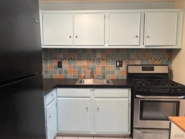 a kitchen with granite countertop white cabinets and stainless steel appliances