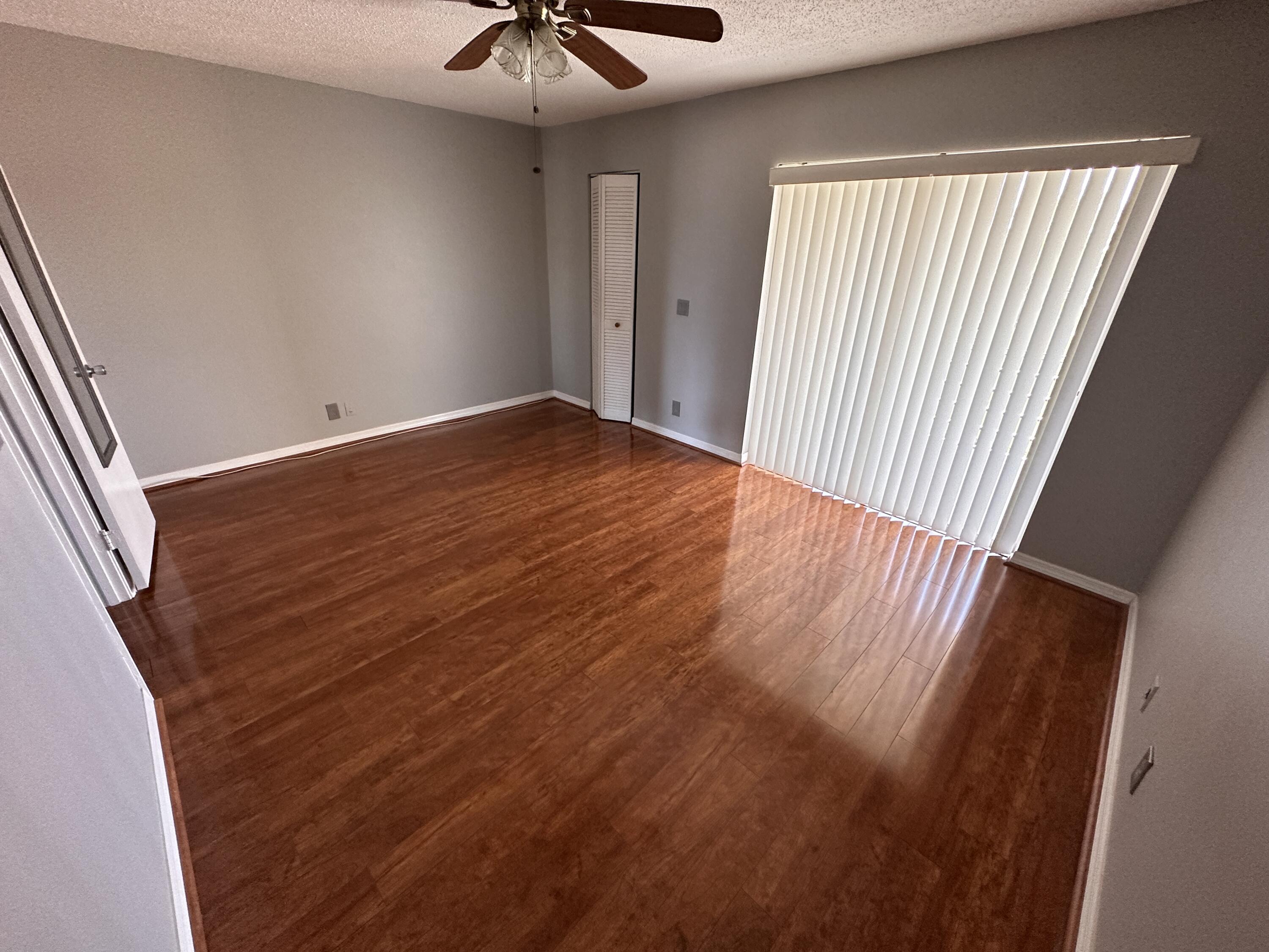 100 Village Green Circle East, Unit 306 Palm Springs, FL 33461 - Photo 6 of 9 wooden floor in an empty room with a window