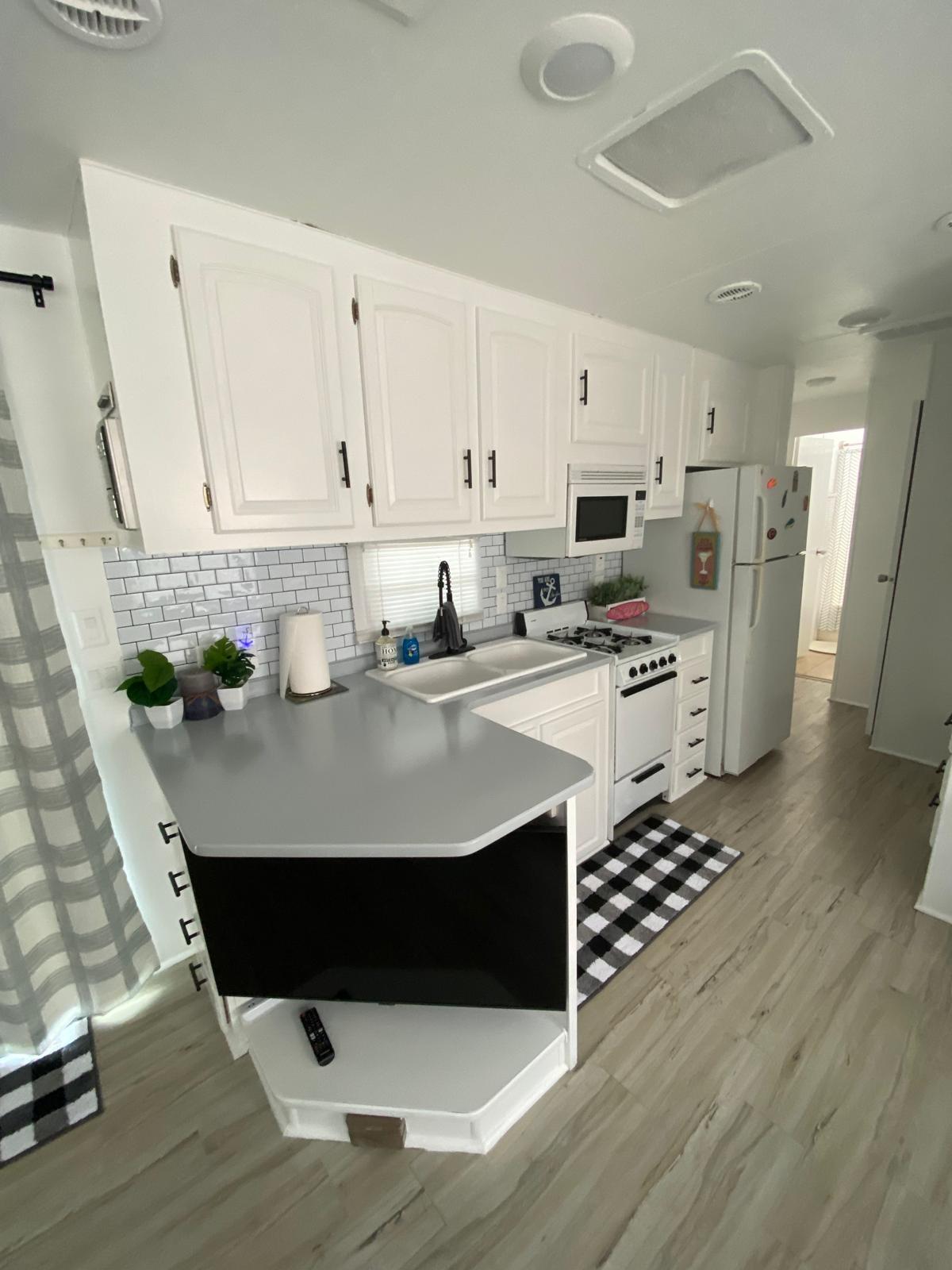 325 Calusa Street, Unit 454 Key Largo, FL 33037 - Photo 2 of 23 a kitchen with stainless steel appliances a sink a stove a refrigerator cabinets and wooden floor