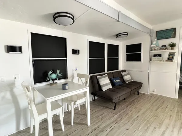 a living room with furniture a flat screen tv and kitchen view