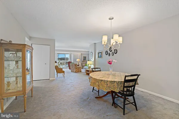 a view of a dining room with furniture and a chandelier
