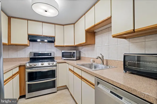a kitchen with stainless steel appliances granite countertop a stove a microwave and cabinets
