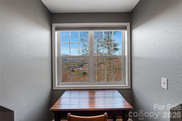 a view of a room that has a window and a table in it