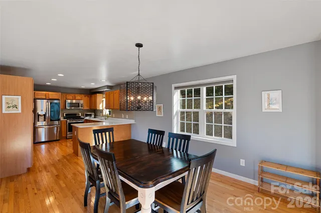 a dining room with furniture a chandelier and wooden floor
