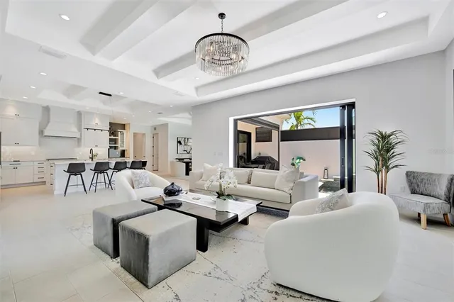 a kitchen with stainless steel appliances kitchen island a table chairs in it and white cabinets