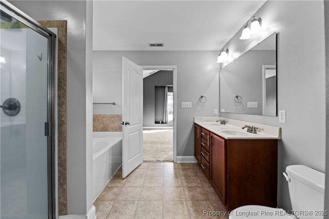 178 Tun Tavern Drive Cameron, NC 28326 - Photo 18 of 30 a large bathroom with a double vanity sink toilet and shower