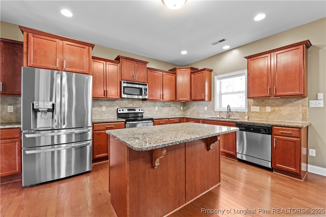 178 Tun Tavern Drive Cameron, NC 28326 - Photo 4 of 30 a kitchen with stainless steel appliances granite countertop a refrigerator stove microwave and sink