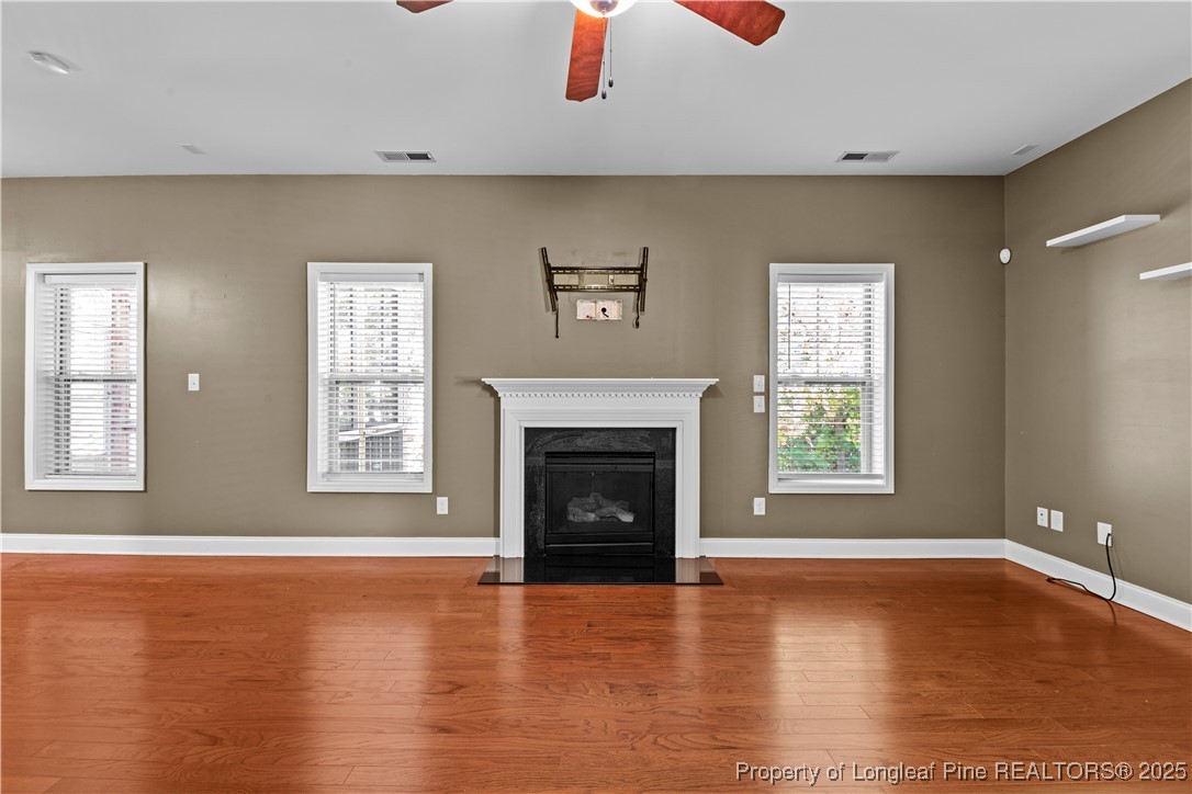 178 Tun Tavern Drive Cameron, NC 28326 - Photo 10 of 30 an empty room with windows fireplace and wooden floor