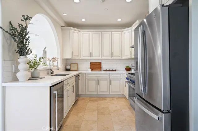 a kitchen with a sink stainless steel appliances and white cabinets