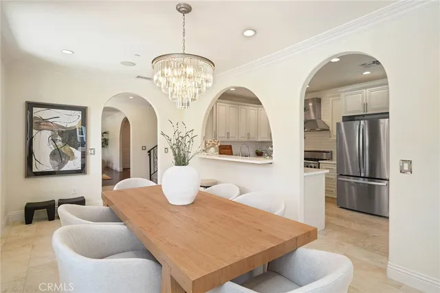 a living room with furniture chandelier and stainless steel appliances