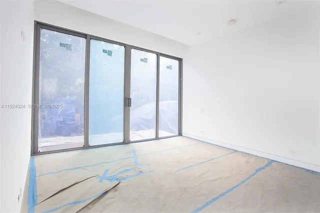 an aerial view of residential houses with outdoor space and a car parked
