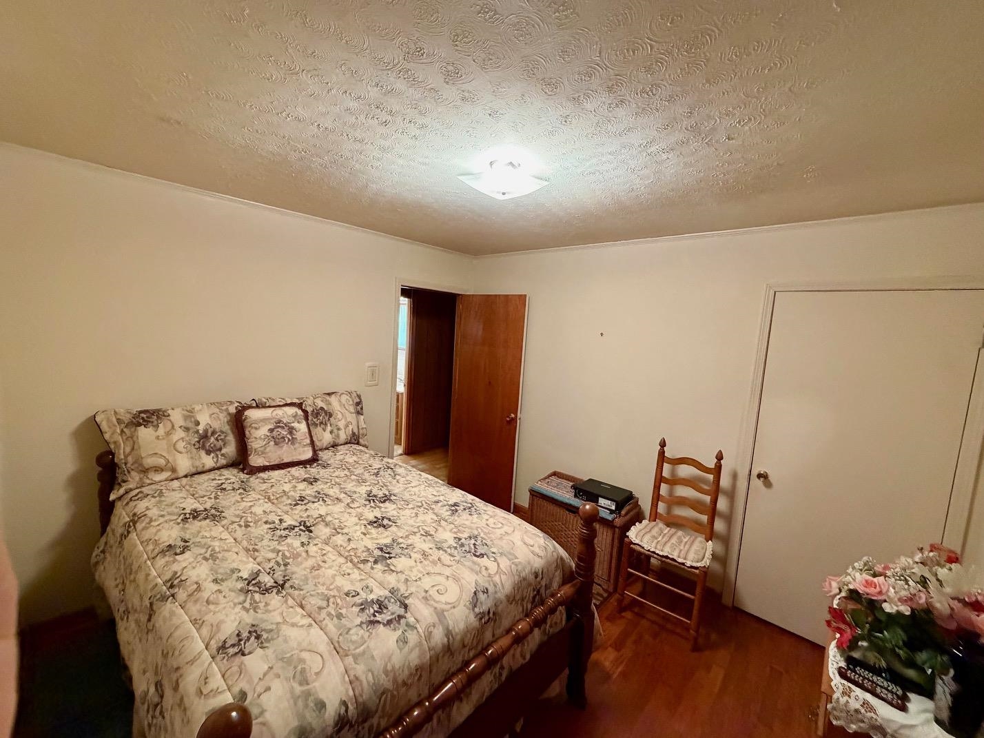 321 Pipkin Road Jackson, TN 38305 - Photo 8 of 16 a bedroom with a bed and wooden floor