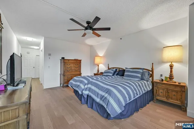 a bedroom with a bed a dresser and potted plants