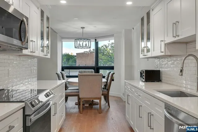 a kitchen with stainless steel appliances a stove a sink and a microwave