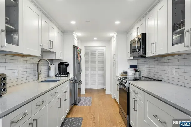 a kitchen with a sink stove top oven and refrigerator