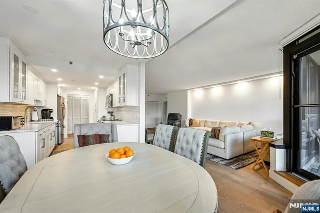 a living room with furniture a chandelier and kitchen view